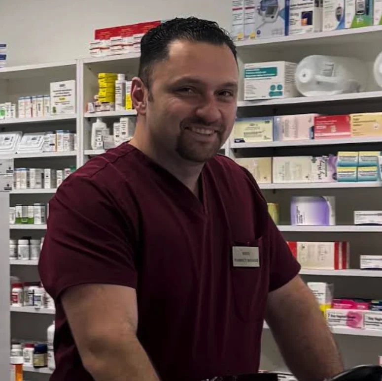 Majed Noshi, a smiling pharmacist standing in a pharmacy